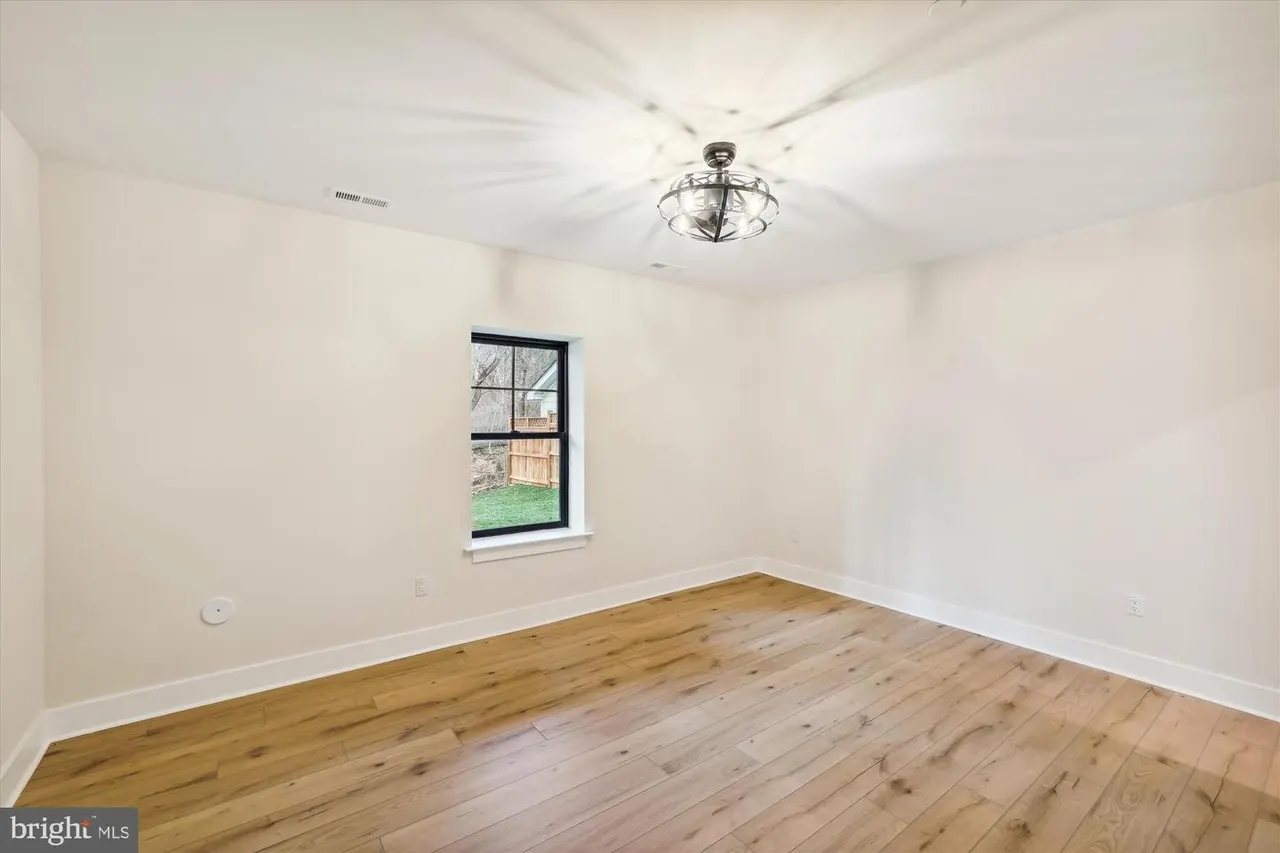Bedroom with hardwood floors and black-framed window