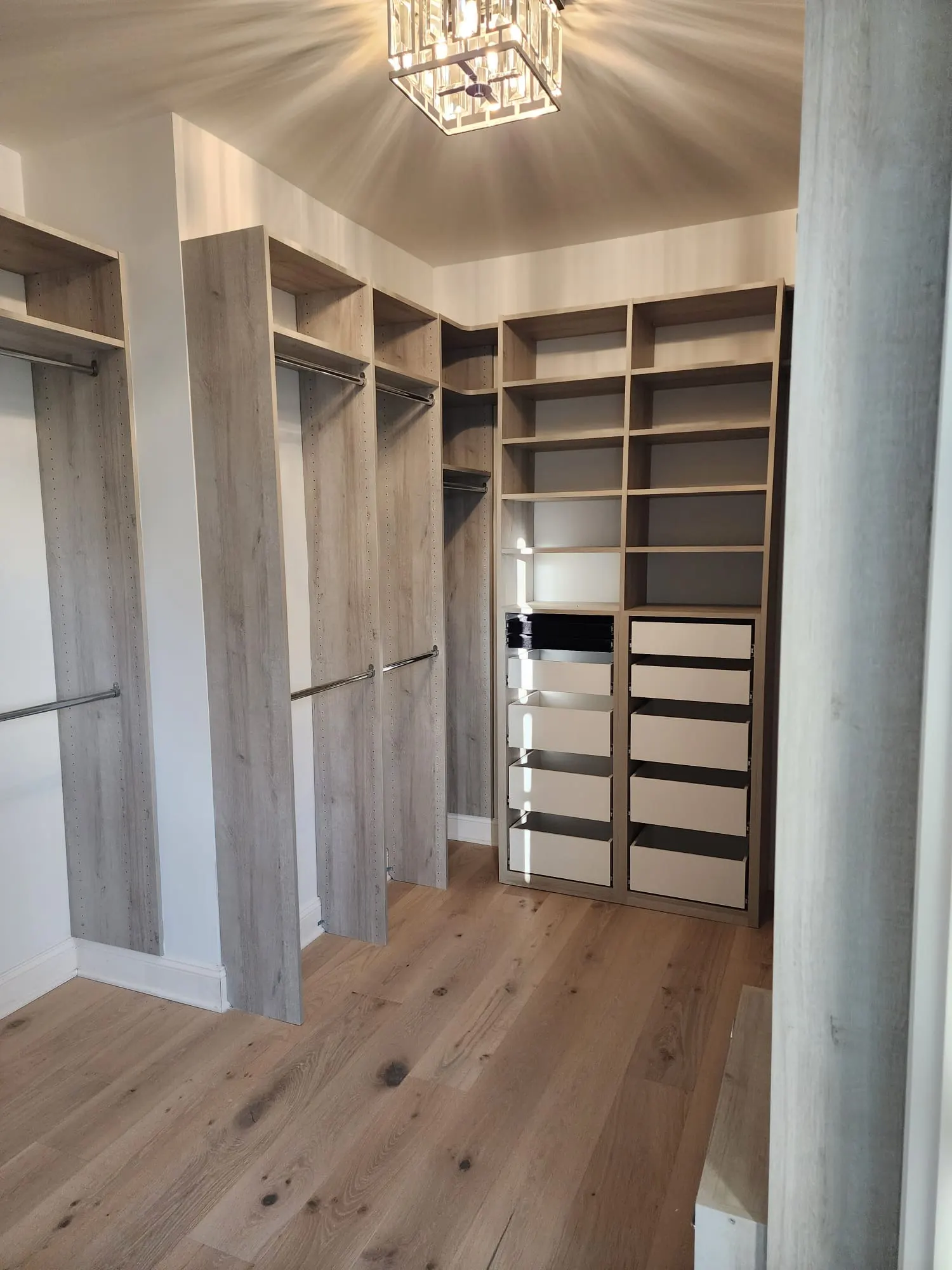 Walk-in closet with custom shelving, drawers, and hanging rods